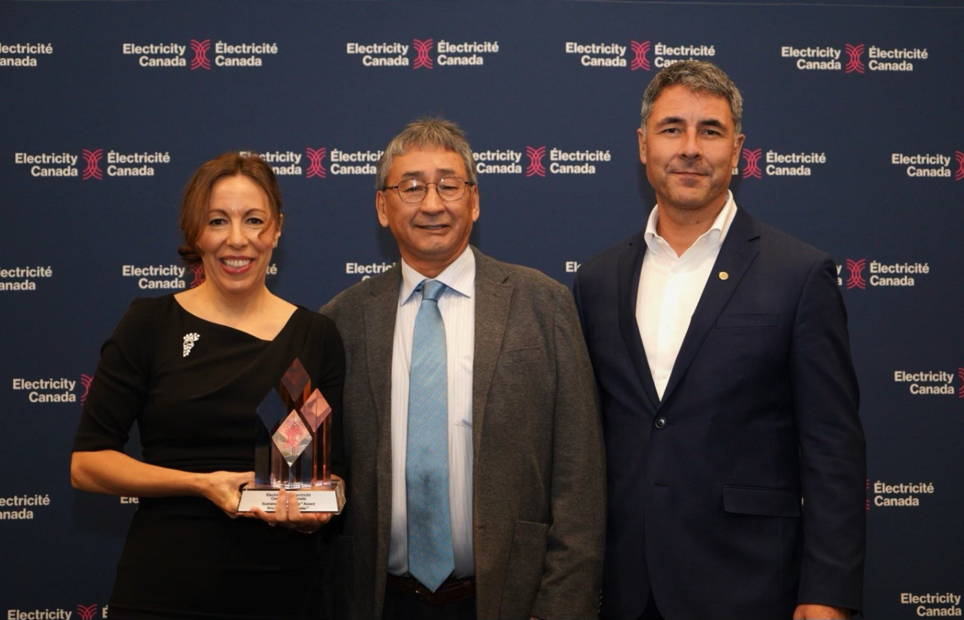 Diana Dominique, Senior Director, Customer Solutions and Sustainability for Electricity Canada, presents Darrell Beaulieu, Chief Executive Officer, Denendeh Investments Incorporated and Jay Massie, Vice President, Northern Development & Indigenous Relations, ATCO Electric with the award on Nov. 26, 2024.